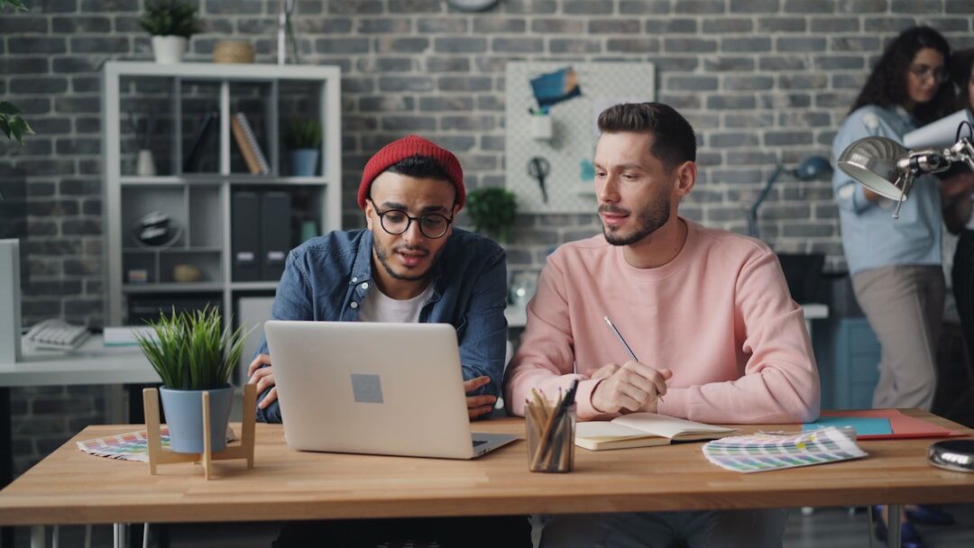 Two colleagues of different ethnicities reviewing video footage together on a laptop