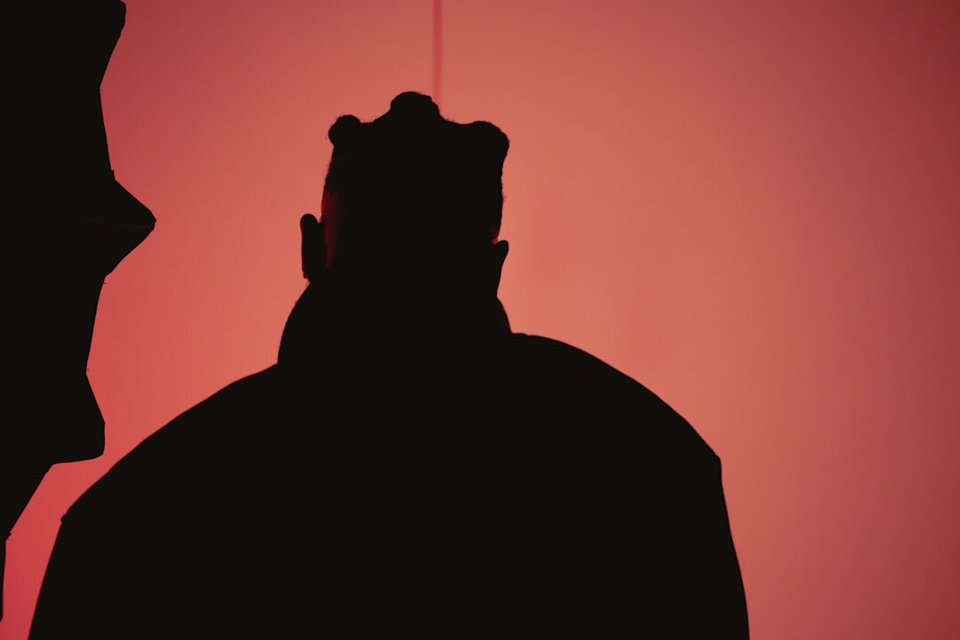 Silhouette of a camera operator filming inside a dark television studio